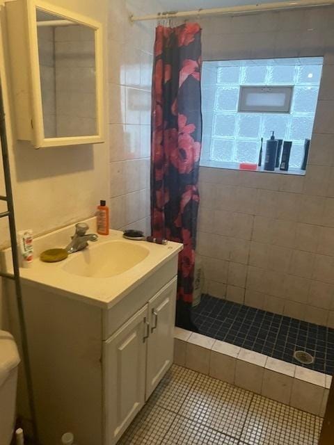 bathroom featuring tile patterned floors, vanity, curtained shower, and toilet