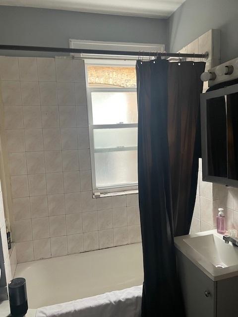 bathroom with decorative backsplash, vanity, and shower / bath combo