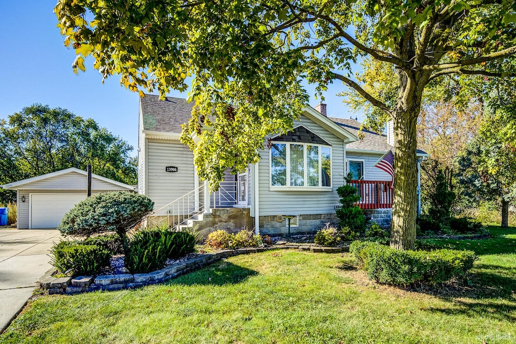 view of front of property with a garage, a front lawn, and an outdoor structure