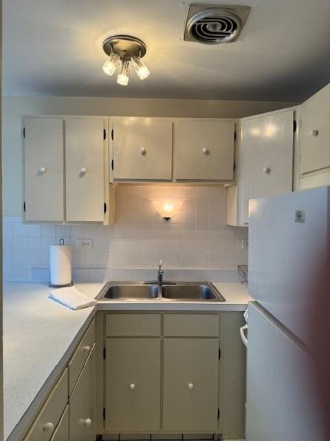 kitchen with sink, backsplash, and white refrigerator