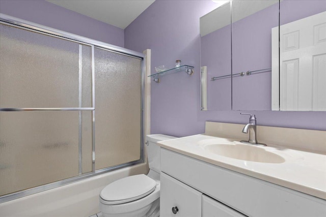 full bathroom featuring combined bath / shower with glass door, vanity, and toilet