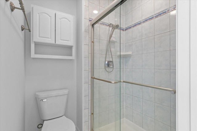 bathroom with an enclosed shower and toilet