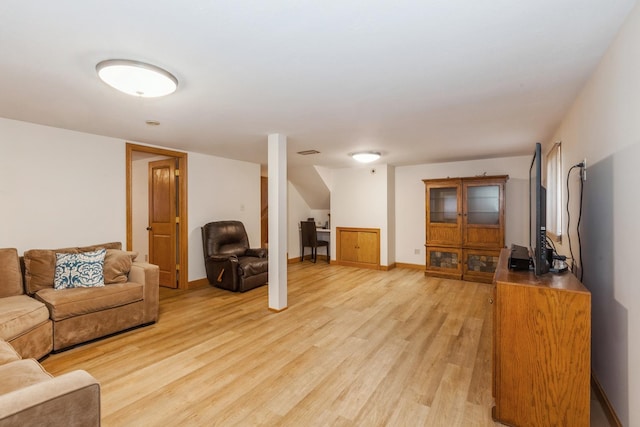 living area featuring visible vents, light wood-style floors, and baseboards