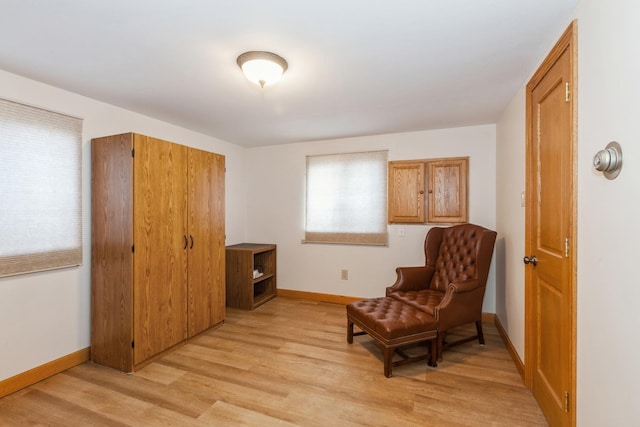 living area with baseboards and light wood finished floors