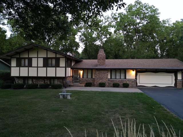 view of front of house featuring a front yard, stucco siding, a chimney, driveway, and an attached garage