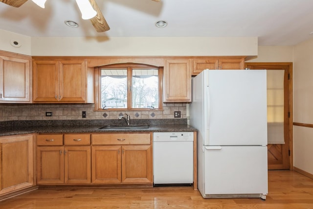 kitchen with a sink, backsplash, white appliances, light wood finished floors, and ceiling fan