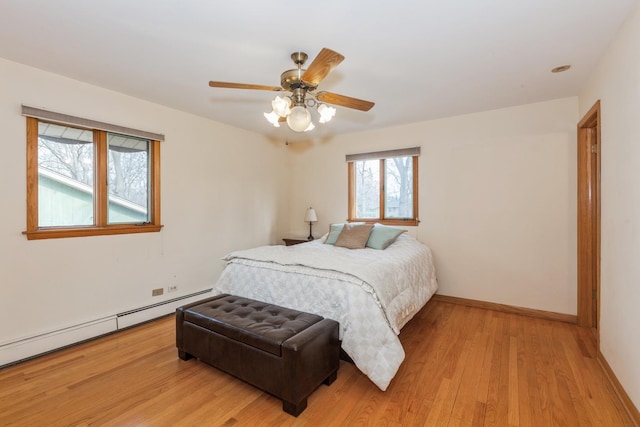 bedroom featuring ceiling fan, light wood-style floors, baseboards, and a baseboard radiator