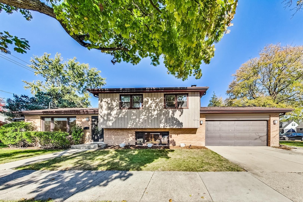 tri-level home with a garage and a front yard