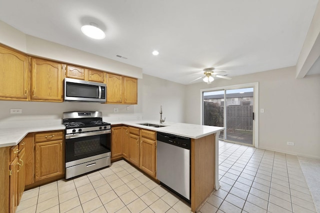 kitchen featuring kitchen peninsula, appliances with stainless steel finishes, ceiling fan, sink, and light tile patterned floors