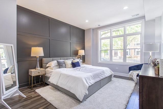 bedroom with dark wood-type flooring and multiple windows