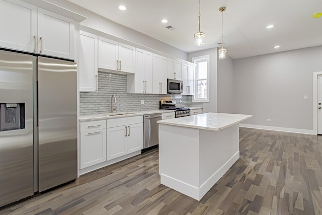 kitchen featuring hardwood / wood-style flooring, decorative light fixtures, white cabinetry, and stainless steel appliances