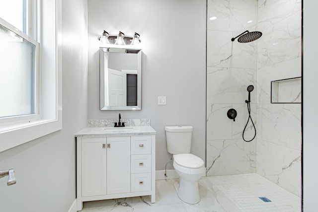 bathroom featuring toilet, vanity, and tiled shower