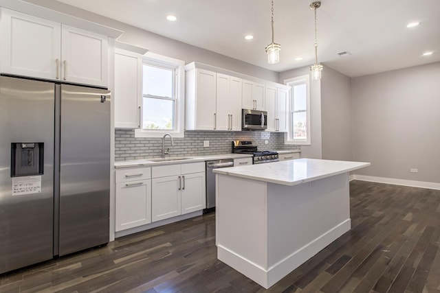 kitchen with white cabinets, appliances with stainless steel finishes, a healthy amount of sunlight, and sink