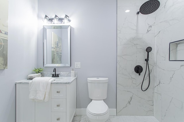 bathroom with vanity, toilet, and a tile shower