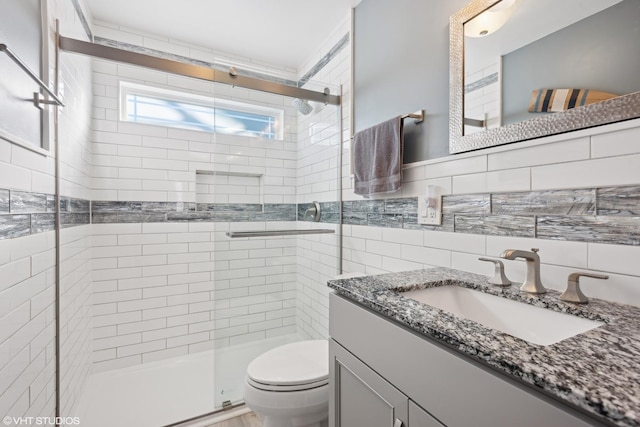 bathroom with an enclosed shower, toilet, decorative backsplash, vanity, and tile walls