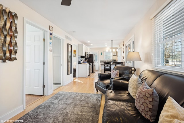 living room with ceiling fan and light hardwood / wood-style floors