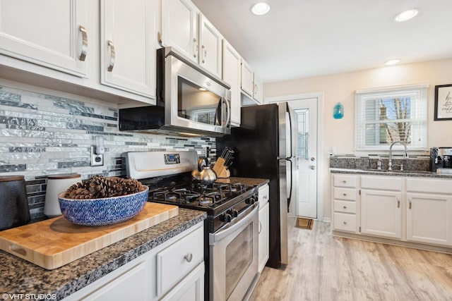 kitchen featuring white cabinetry, sink, appliances with stainless steel finishes, and tasteful backsplash