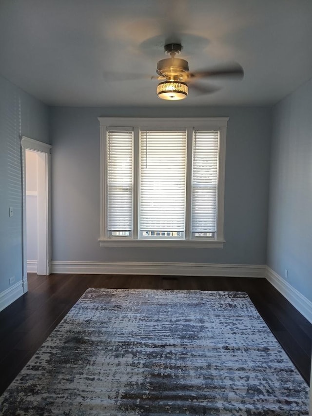 spare room featuring ceiling fan and dark wood-type flooring