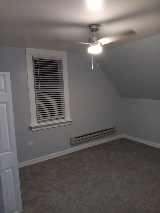 additional living space with ceiling fan, dark carpet, lofted ceiling, and a baseboard heating unit