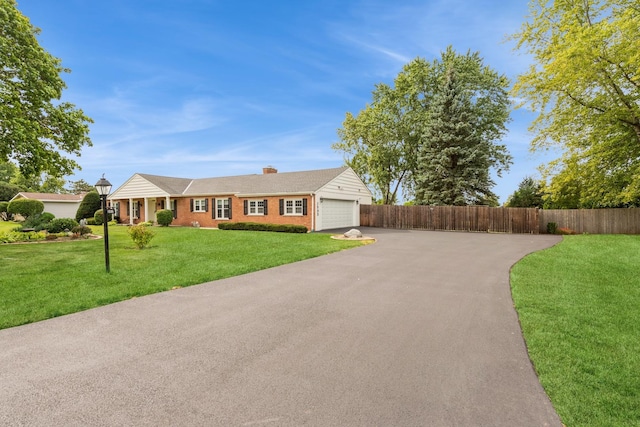 single story home featuring a front yard and a garage