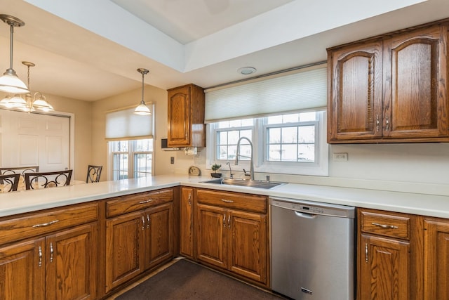 kitchen featuring dishwasher, kitchen peninsula, sink, and decorative light fixtures