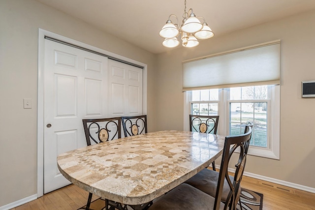 dining area with a notable chandelier and light hardwood / wood-style flooring