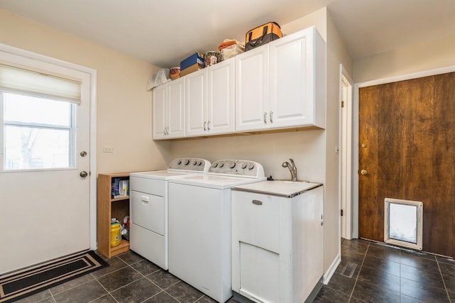 laundry area with cabinets, separate washer and dryer, and dark tile patterned flooring