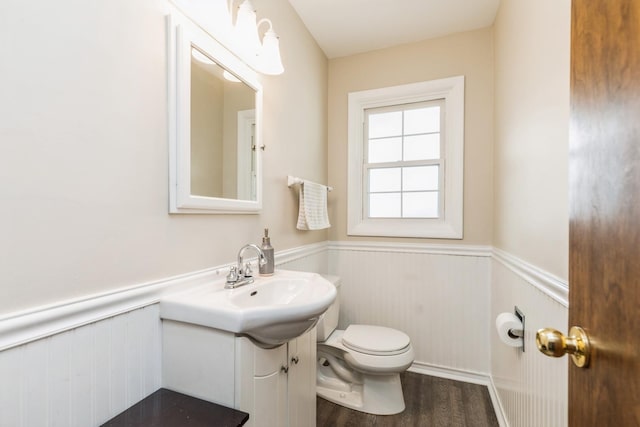 bathroom with hardwood / wood-style flooring, toilet, and sink