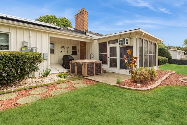 rear view of house featuring central AC, a sunroom, a yard, and solar panels