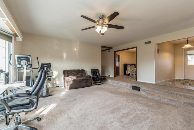 carpeted home office featuring ceiling fan