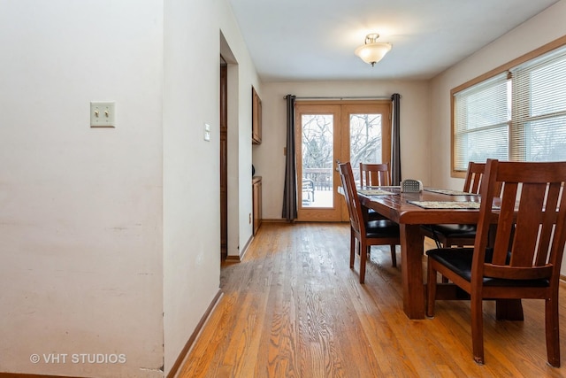 dining room with french doors and light hardwood / wood-style flooring