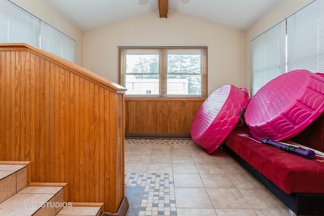 interior space featuring light tile patterned floors, vaulted ceiling with beams, and wooden walls