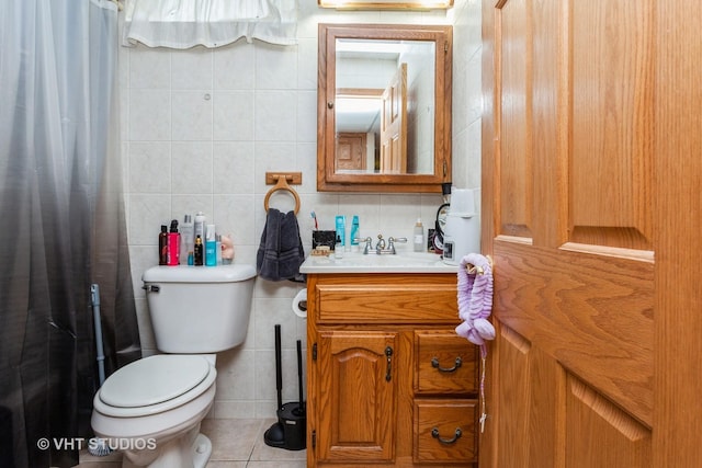 bathroom featuring tasteful backsplash, vanity, tile walls, tile patterned flooring, and toilet