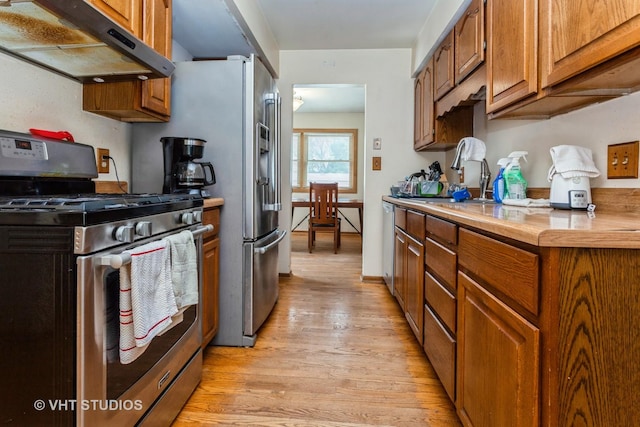 kitchen with high end stove, sink, and light hardwood / wood-style floors