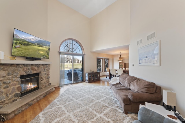 living room with hardwood / wood-style flooring, a fireplace, and high vaulted ceiling