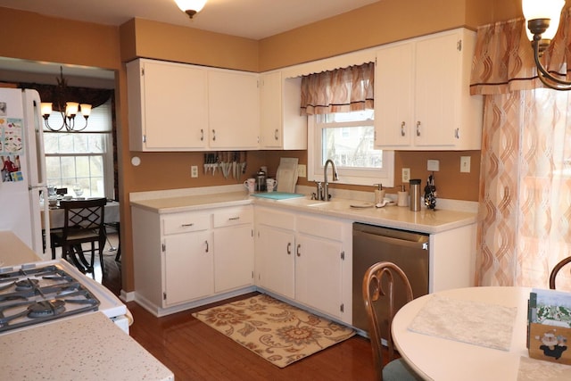 kitchen with hanging light fixtures, white cabinets, sink, and white appliances