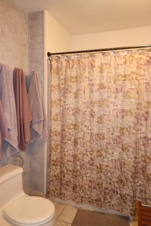 bathroom featuring toilet and a shower with shower curtain