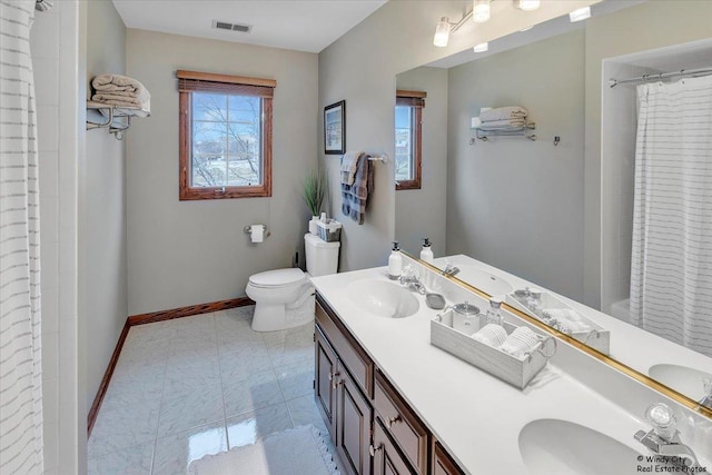 bathroom featuring tile patterned flooring, vanity, toilet, and curtained shower