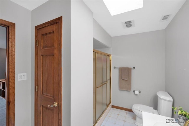 bathroom with vanity, a skylight, toilet, and walk in shower