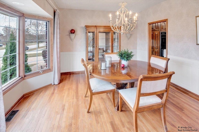 17224 Briar Dr, Tinley Park, IL 60487 - dining room with a chandelier, healthy amount of natural light, wainscoting, light wood-style flooring, and a decorative wall