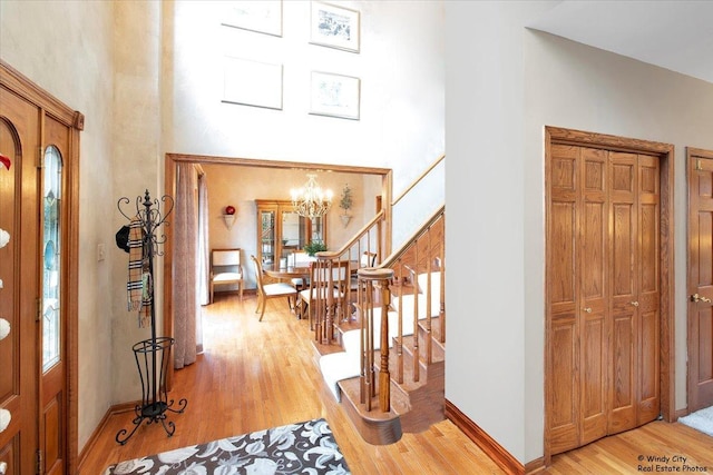 17224 Briar Dr, Tinley Park, IL 60487 - entrance foyer with a towering ceiling, light wood-type flooring, stairway, a chandelier, and baseboards