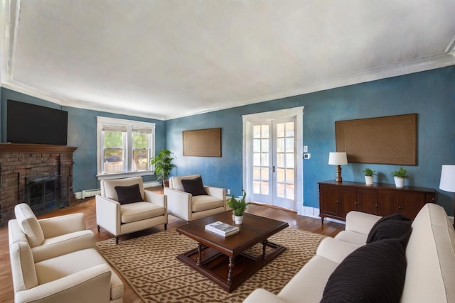 living room featuring french doors, a baseboard heating unit, crown molding, wood-type flooring, and a fireplace