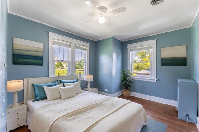 bedroom with ceiling fan, dark wood-type flooring, and ornamental molding