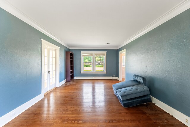 unfurnished room with wood-type flooring, french doors, ornamental molding, and a baseboard heating unit