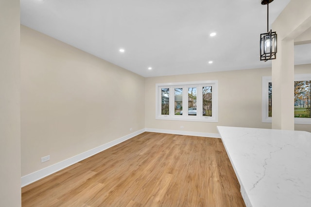 unfurnished living room featuring light hardwood / wood-style floors and an inviting chandelier