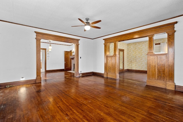 spare room featuring ceiling fan, ornamental molding, dark hardwood / wood-style floors, and decorative columns