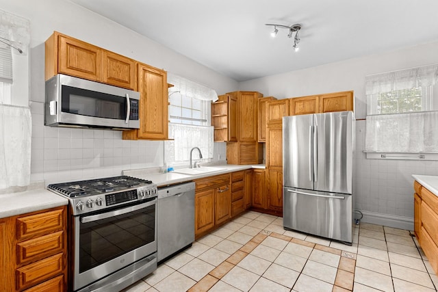 kitchen featuring sink, light tile patterned floors, decorative backsplash, and appliances with stainless steel finishes