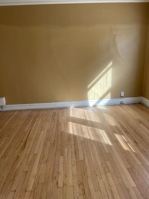 unfurnished room featuring baseboards and light wood-style floors