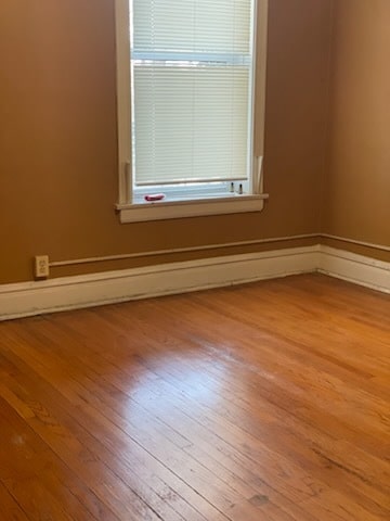 empty room featuring wood finished floors and baseboards