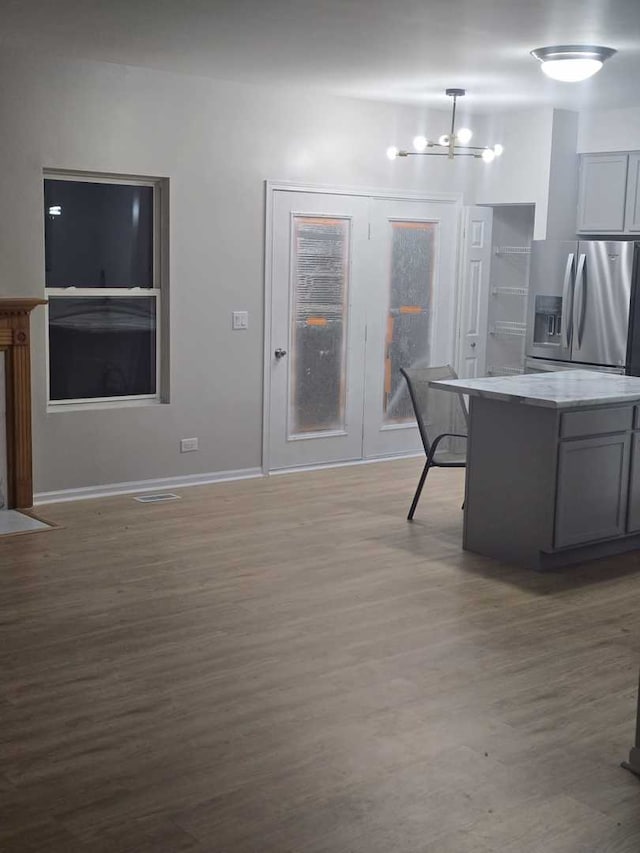 kitchen featuring gray cabinetry, light hardwood / wood-style floors, and stainless steel refrigerator with ice dispenser